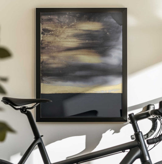 Black and Gold by Alyson Storms — black-framed canvas displayed behind a bicycle