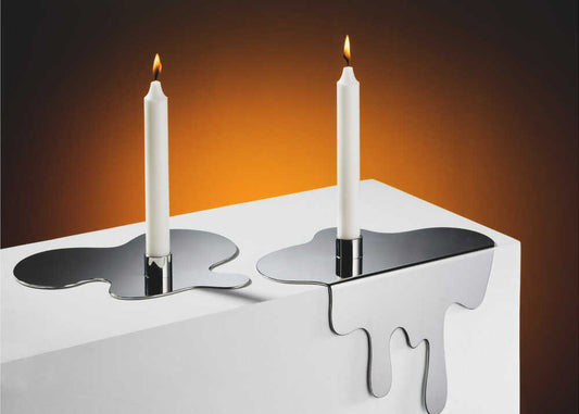 candles by Rostovskiy Anton, front view of the artwork; two lit white candles on dark holders above a white surface with melting-looking edges.