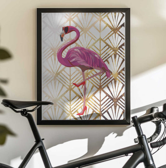 Flamingo Art Deco by Sarah Manovski, black-framed artwork above a bicycle; a bright pink flamingo wearing sunglasses against a gold-toned geometric pattern.