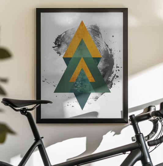 Poster Abstraction Art 011 by Rafal Kulik, black-framed artwork above a bicycle; stacked green and gold-toned triangles over a loose black circular brush mark.