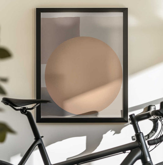 Sphere of Warmth by Little Dean, black-framed artwork above a bicycle; soft peach sphere against beige geometric planes.