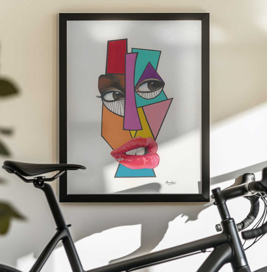 Abstract V1 by Manasseh Johnson Sr., black-framed artwork above a bicycle; fragmented multicolor face with realistic eyes and red lips.