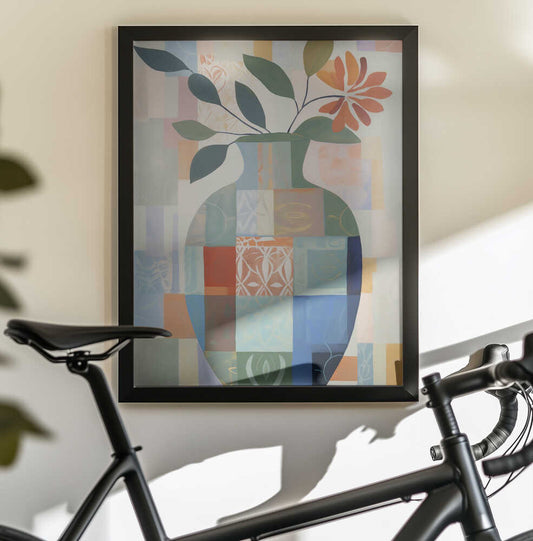 Abstract Vase by Andreas Magnusson, black-framed artwork above a bicycle; a patchwork blue-green vase with leafy stems and an orange flower.