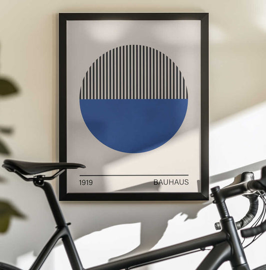 Bauhaus art 1 by Vitor Costa, black-framed artwork above a bicycle; a circle with a striped black upper half and solid blue lower half above Bauhaus lettering.