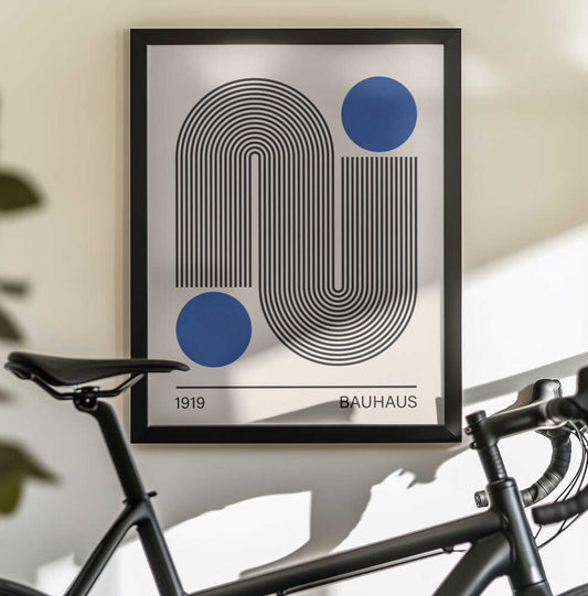 Bauhaus art 2 by Vitor Costa, black-framed artwork above a bicycle; opposing black line arches paired with two blue circles and Bauhaus lettering.