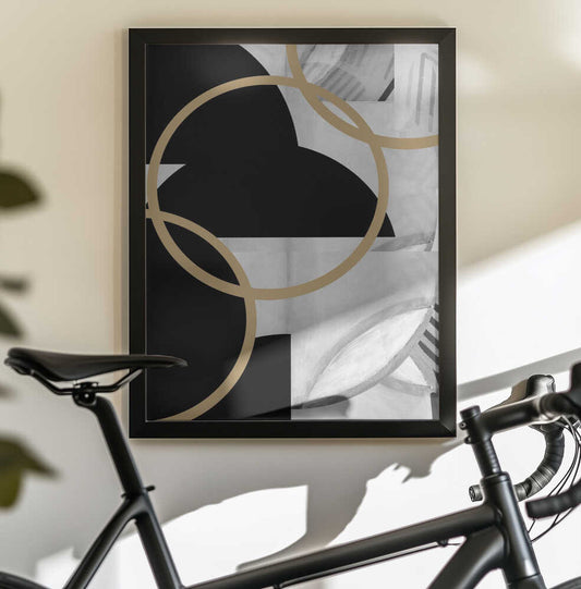 Black and White Stripes Gold Spheres No3 by cartissi, black-framed artwork above a bicycle; overlapping gold-toned rings on black and white abstraction.