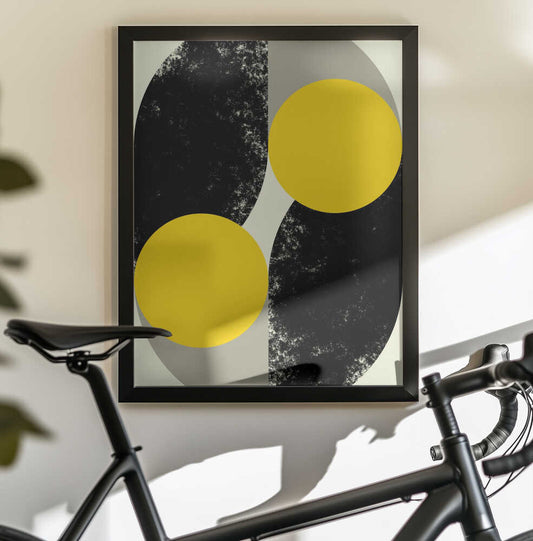 Duality in Motion by Petr Strnad, black-framed artwork above a bicycle; two yellow circles crossing opposing black and gray curved fields.