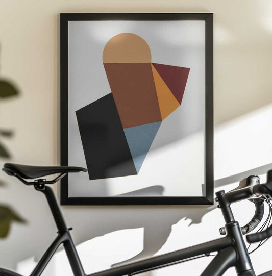 Geo 57 (2022) by Ildefonso Martín, black-framed artwork above a bicycle; overlapping ochre, rust, orange, blue and black angular shapes with a rounded top.