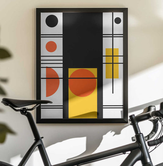 Geometric Shapes by Nicholas, black-framed artwork above a bicycle; a tall black panel with orange circles, yellow rectangles and fine intersecting lines.