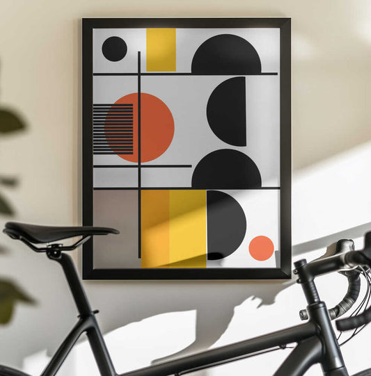 Geometric Shapes by Nicholas, black-framed artwork above a bicycle; stacked black semicircles with orange circles, yellow blocks and fine black lines.
