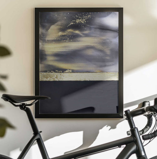 Gold Noir 2 by Alyson Storms — black-framed canvas displayed behind a bicycle