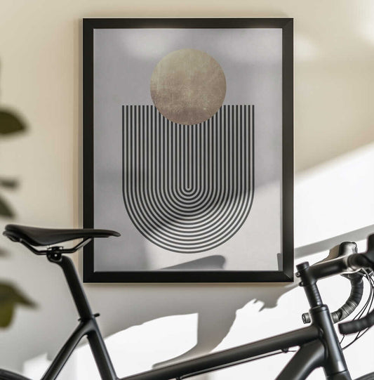Lines and circles 21 by Vitor Costa, black-framed artwork above a bicycle; a mottled gold-toned circle above a deep U-shaped black line pattern.