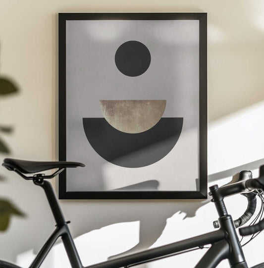 Lines and circles 24 by Vitor Costa, black-framed artwork above a bicycle; a floating black circle above nested gold-toned and black semicircles.