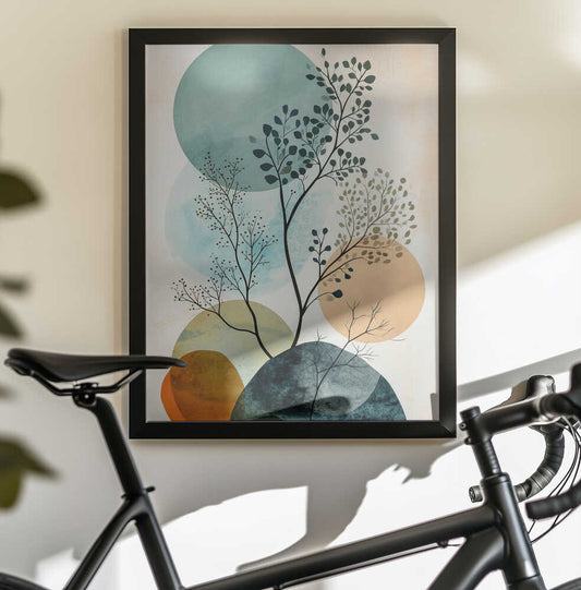Minimal Calms 6 by Justyna Jaszke, black-framed artwork above a bicycle; fine branching foliage layered over pale teal, peach and dark green circles.