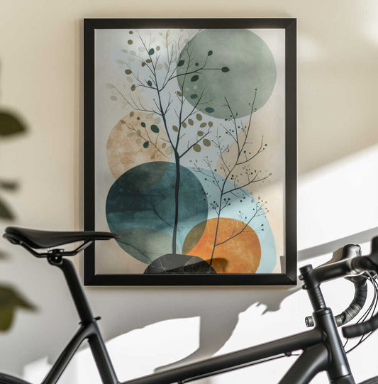 Minimal Calms 8 by Justyna Jaszke, black-framed artwork above a bicycle; delicate leafy branches over sage, teal and ochre circular shapes.