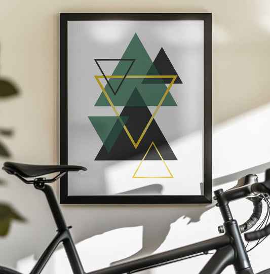 Minimal Triangle Collection #2 by jay stanley, black-framed artwork above a bicycle; overlapping green and black triangles with yellow outlines.