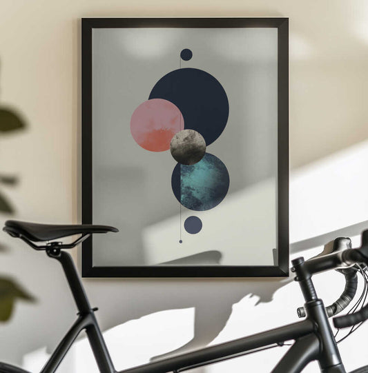 Moon Planet Equinox by Emanuela Carratoni, black-framed artwork above a bicycle; a vertical arrangement of dark blue, coral and textured moon-like circles.