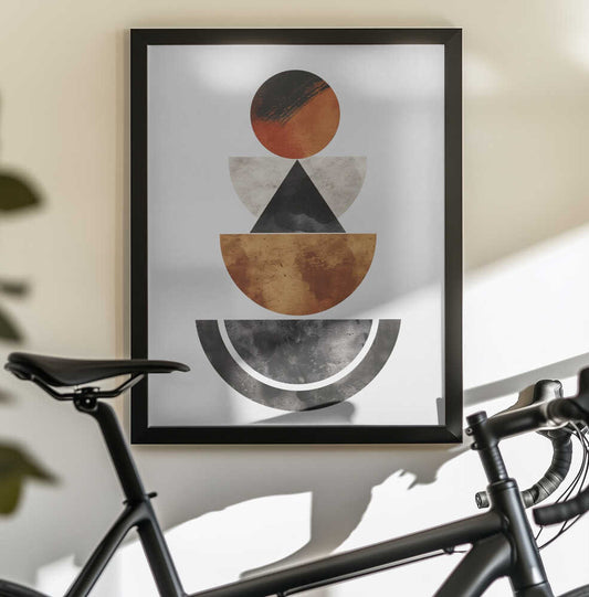 Perfectly Balanced by SHANDU, black-framed artwork above a bicycle; a warm red disc above stacked cream, bronze-toned and black geometric bowls.
