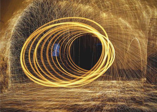 Playing with fire by Milan Uhrin AFIAP AZSF, front view of the artwork; looping golden light trails surrounded by fine sparks.