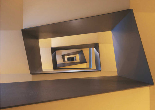 Several geometric forms in shades from yellow to brown of a staircase in Frankfurt by Marc van Oostrum, front view of the artwork; yellow and brown rectangular stairwell viewed through its center.
