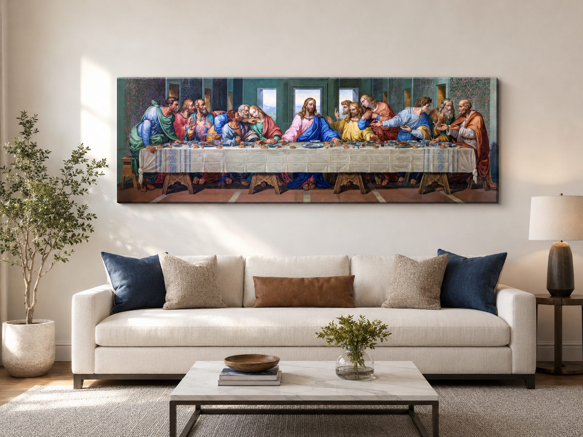 A large horizontal canvas print of Leonardo da Vinci's Last Supper displayed on a beige wall above a modern white sofa in a styled living room.