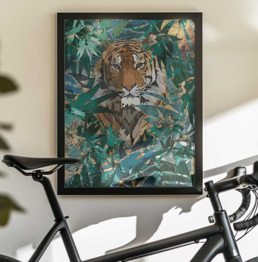 Tiger in the jungle 2 by Sarah Manovski, black-framed artwork above a bicycle; front-facing tiger surrounded by layered green jungle leaves.