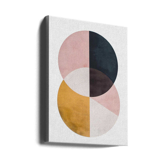 United Spheres by SHANDU, gallery-wrapped canvas viewed at an angle; two overlapping circles divided into dusty pink, charcoal, ochre and pale sections.