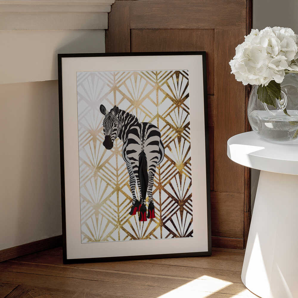 Zebra Heels Art Deco by Sarah Manovski, black-framed artwork with a white mat beside a table; a zebra in red high heels against a pale gold-toned Art Deco fan pattern.