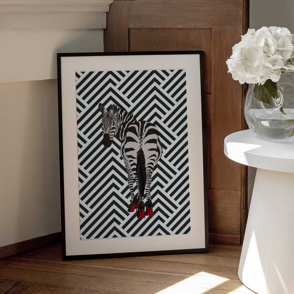 Zebra heels retro by Sarah Manovski, black-framed artwork with a white mat beside a table; a zebra wearing red high heels against a black-and-white chevron background.